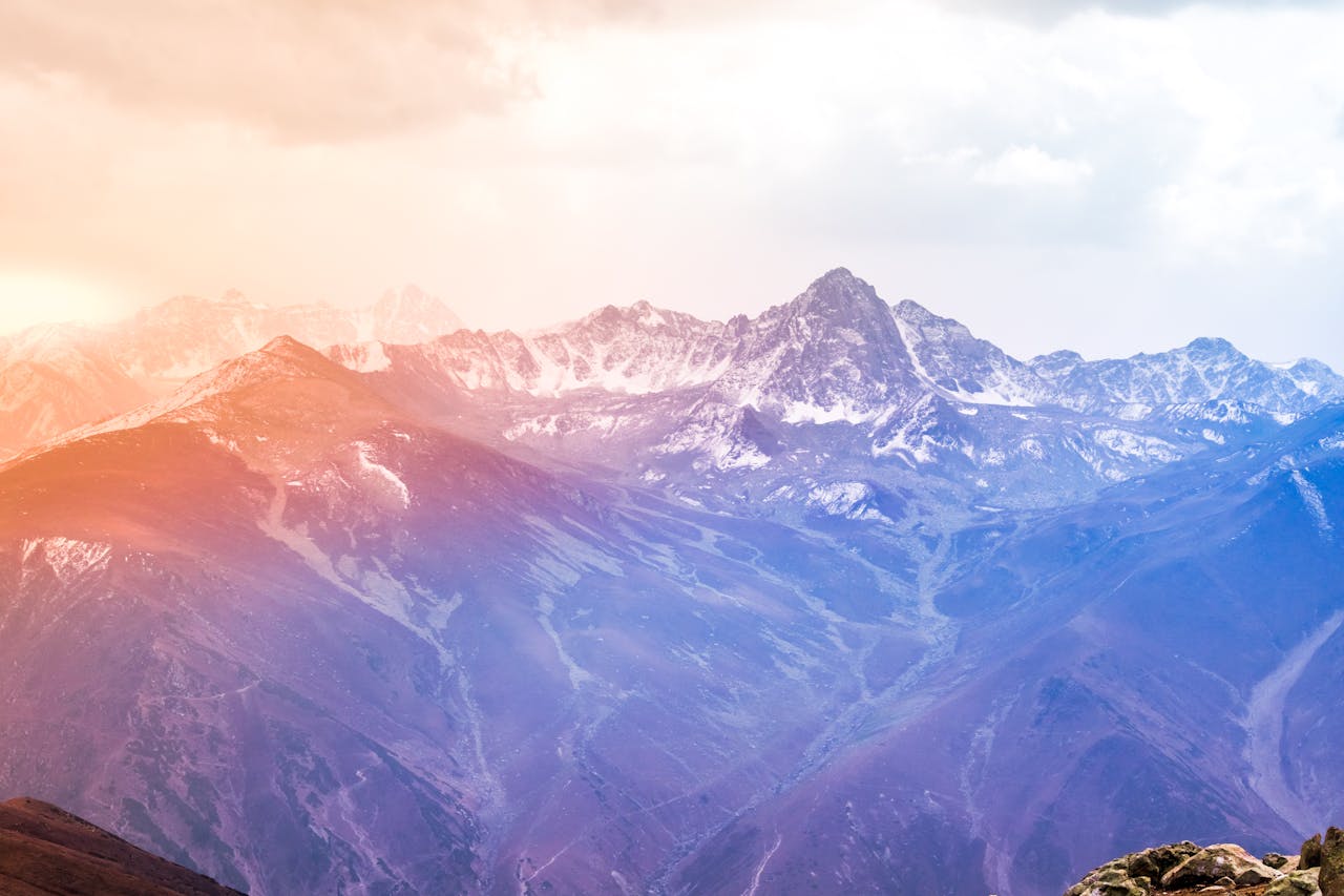 Breathtaking view of snow-covered mountains at sunrise with a vibrant sky.